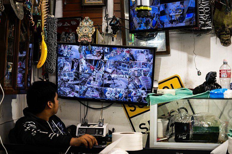 A person watching multiple cameras that are set up in store.