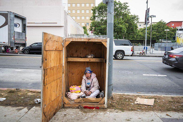 A person sitting in a shipping box.