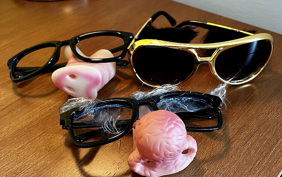 3 sunglasses and pink nose props on the table