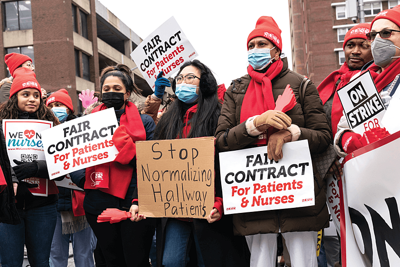 Nurses standing outside a hospital with protest banners