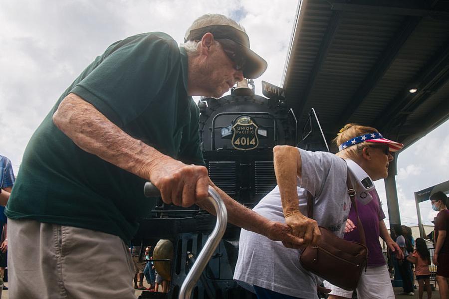 An old couple walking in a crowded space