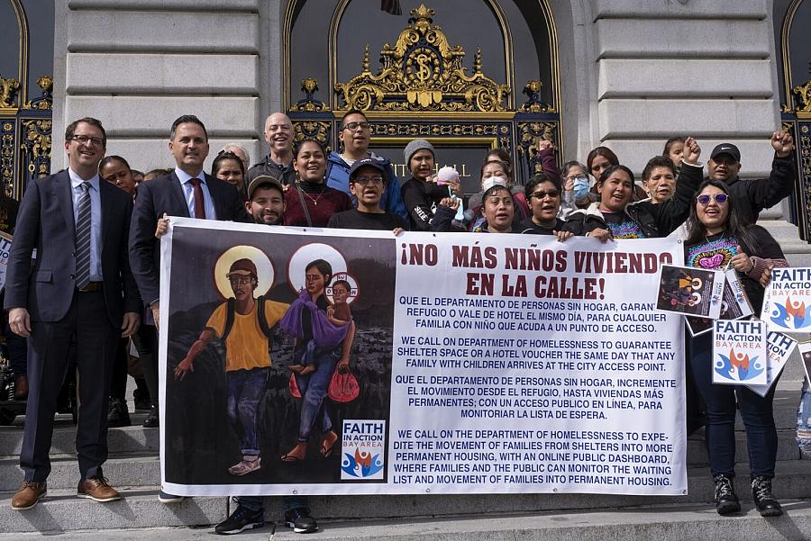 People holding a banner in front of a building