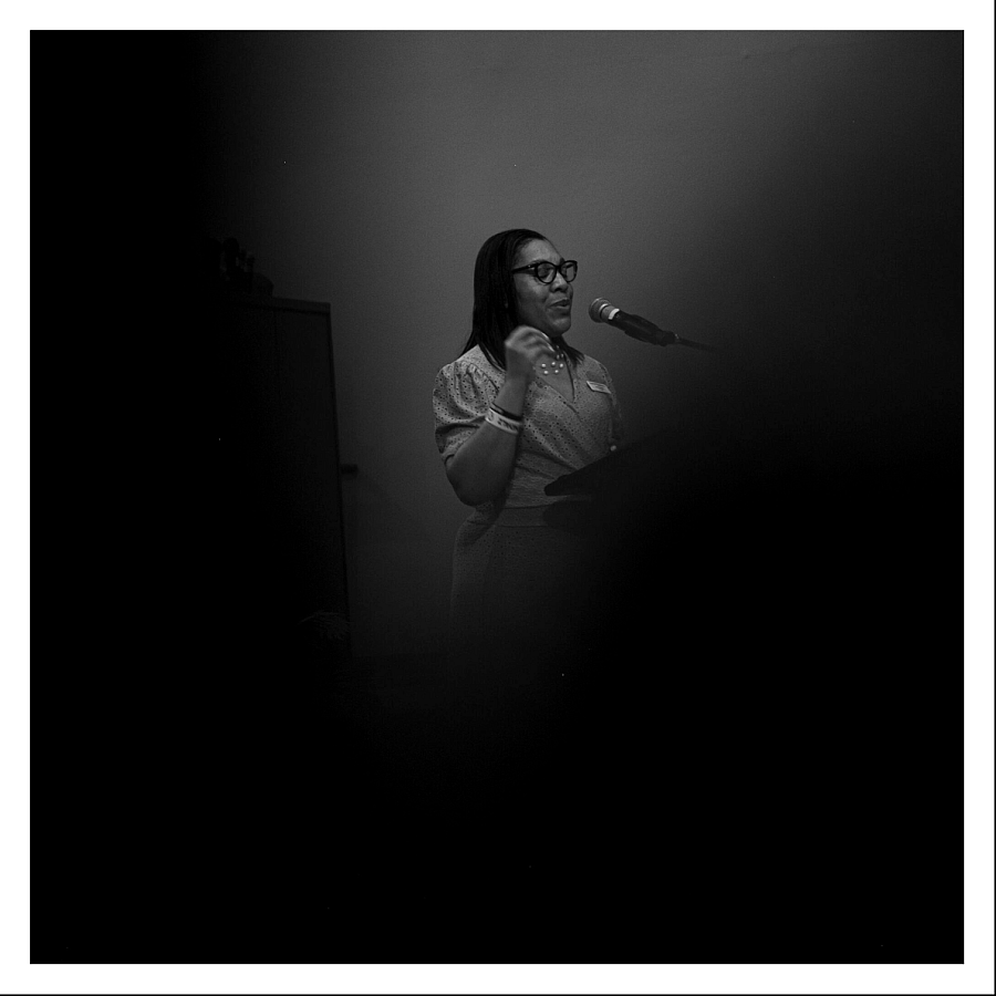 Black and white picture of a person in front of a mic