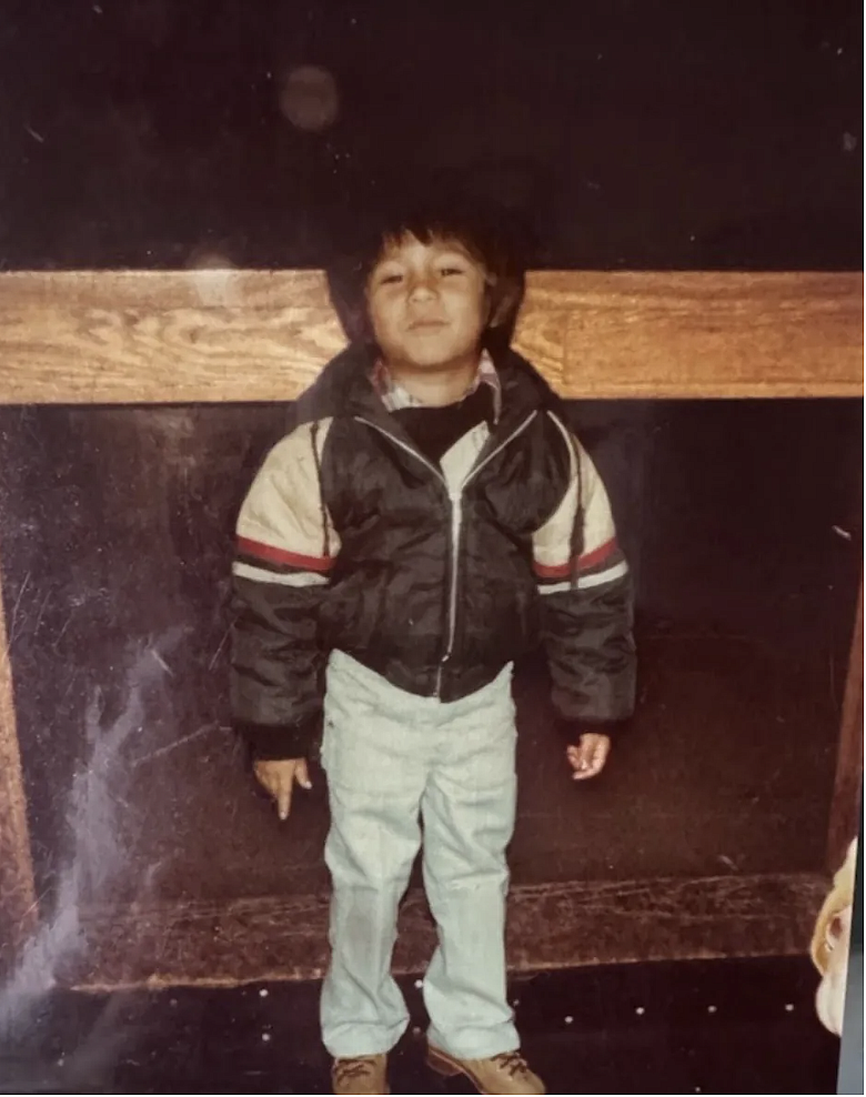 Child standing in front of a wooden beam