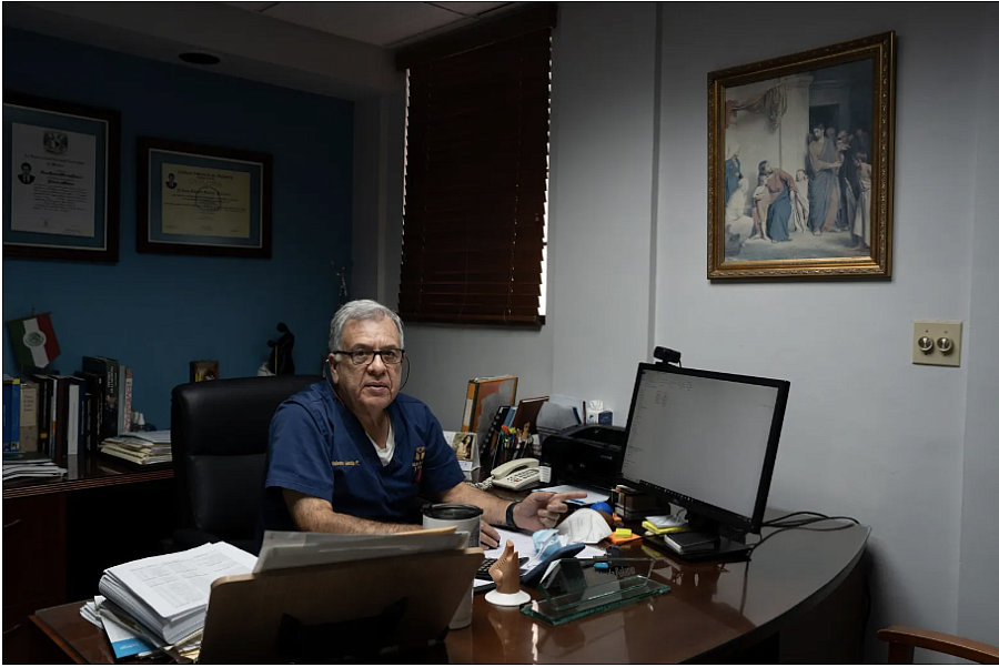 Person in scrubs sitting at a desk