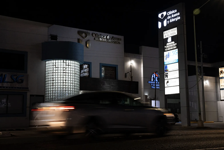 Car driving by a building at night