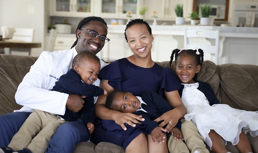 Dr. Terrance McGill, a Black physician in Bakersfield, shares a laugh with his wife and three children on a sofa
