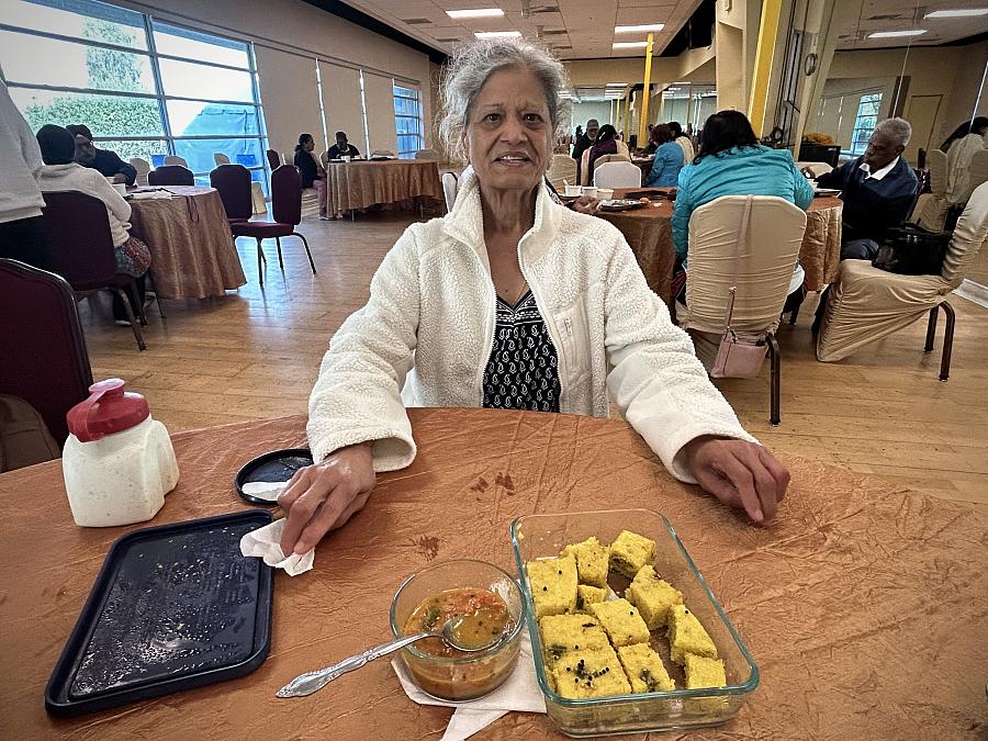 Person seated at a table with a plate of food