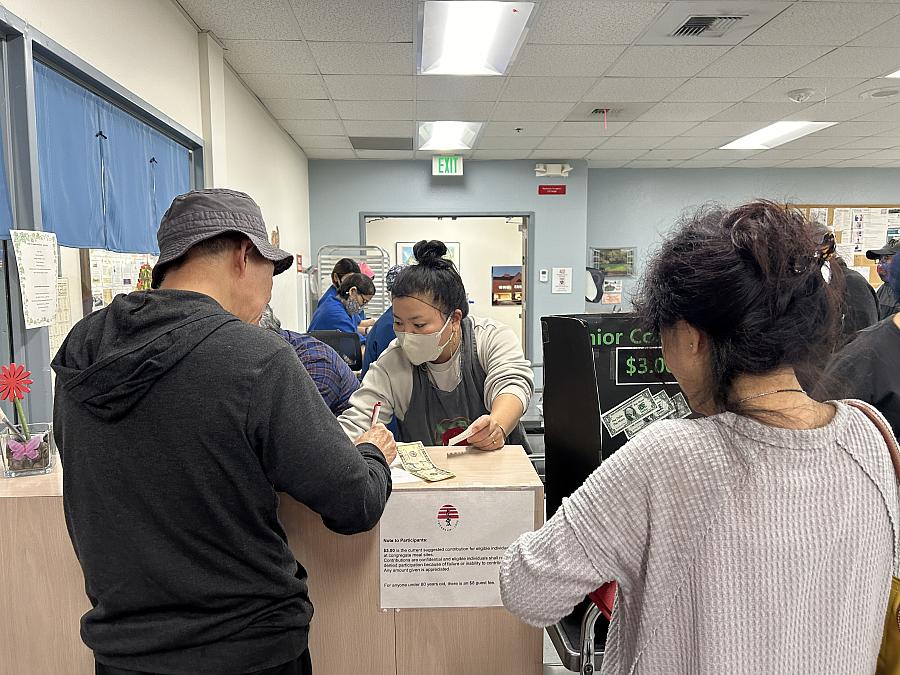 A person behind a desk attending to 2 people 