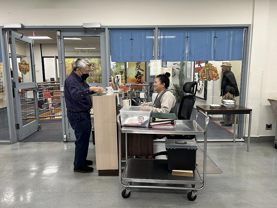 Person speaking to someone seated at a desk