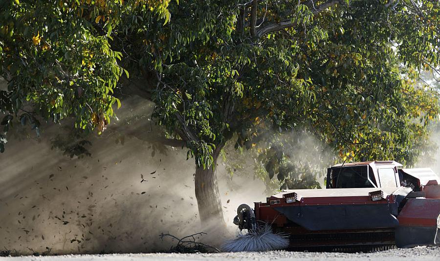 An image of a tractor blowing dust in the farm.