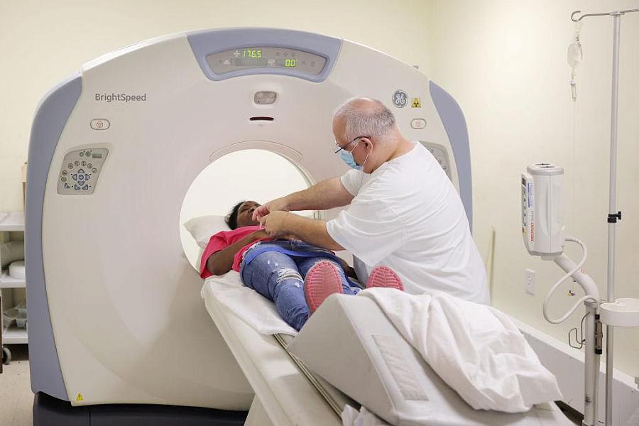 Person attending to someone laying in an MRI machine