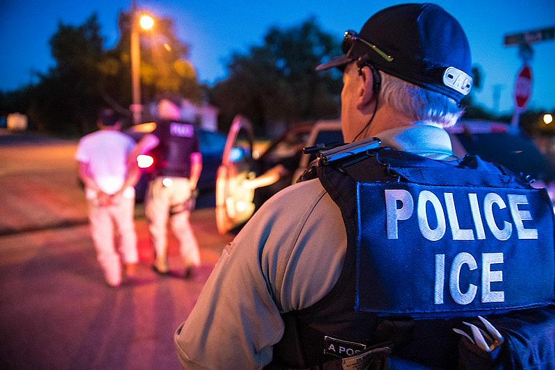 A police wearing ICE jacket 