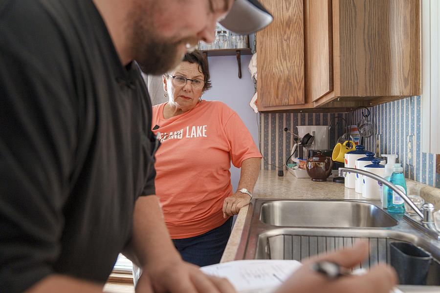 Person performing a water test with another person watching