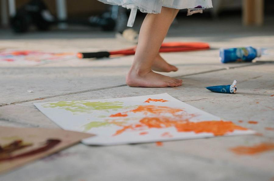 A child standing next to a painting