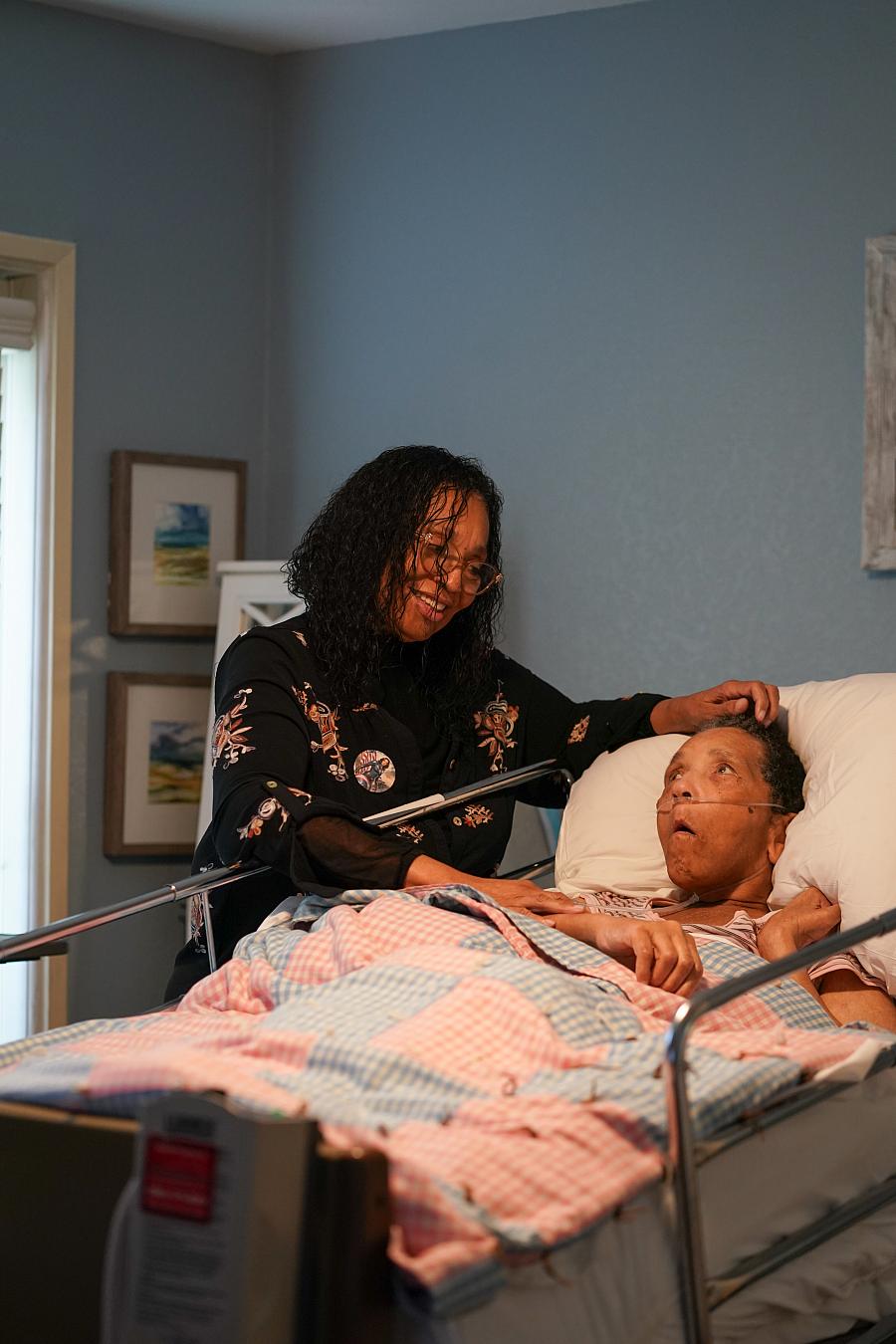 Person posing with someone in a hospital bed