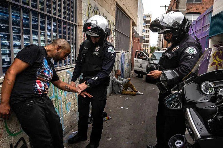 Image of cops checking pulse of a person suspected to be under the influence of fentanyl in MacArthur Park's aisle