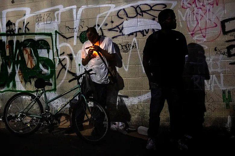 An image of person smoking in night in the alley