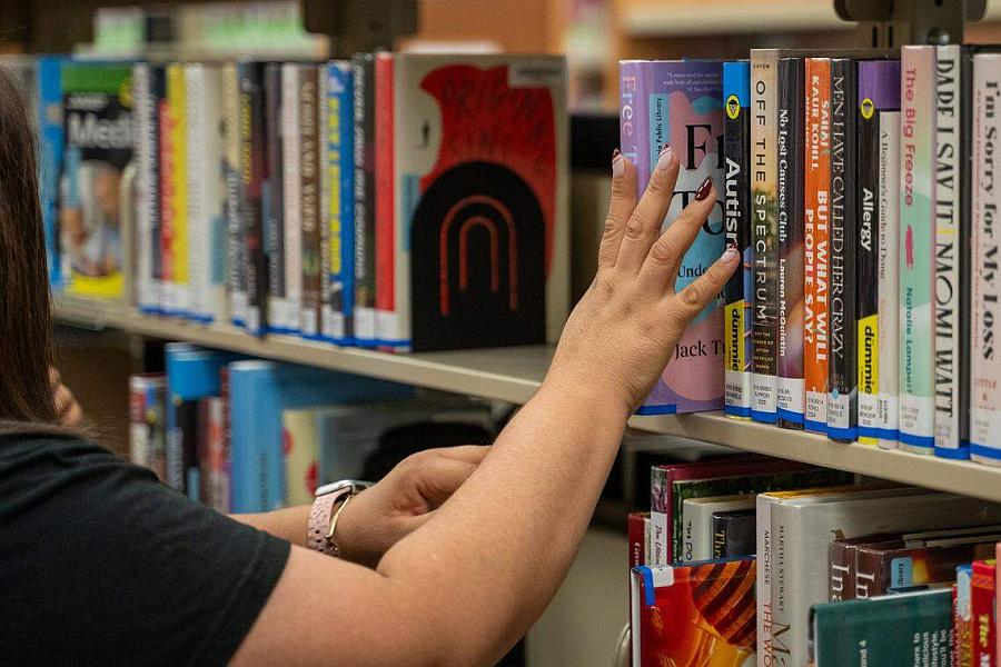 Person browsing through a library rack