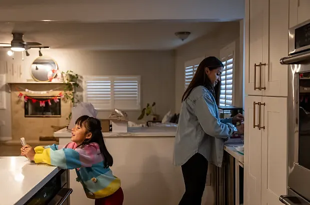 Child and adult in kitchen during morning routine