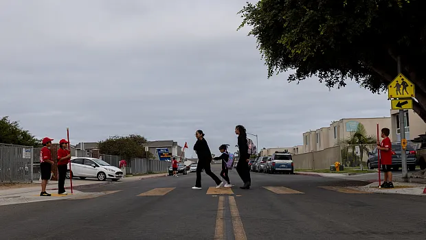 Mother and child crossing street near school