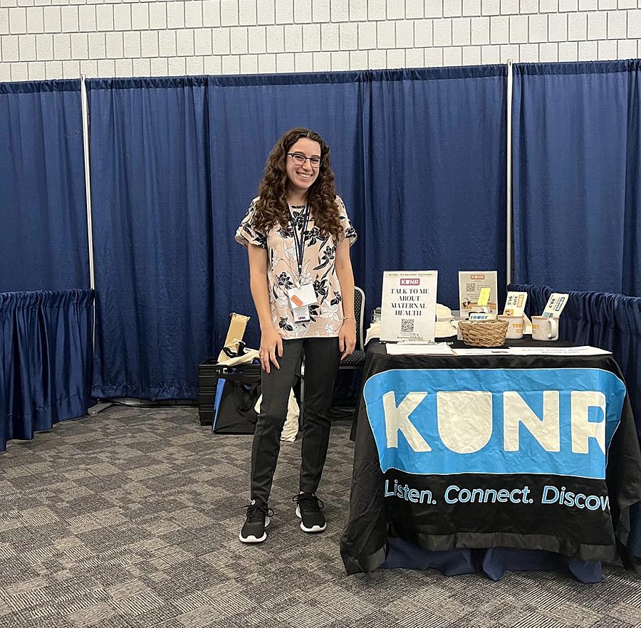 Image of a person standing near table smiling