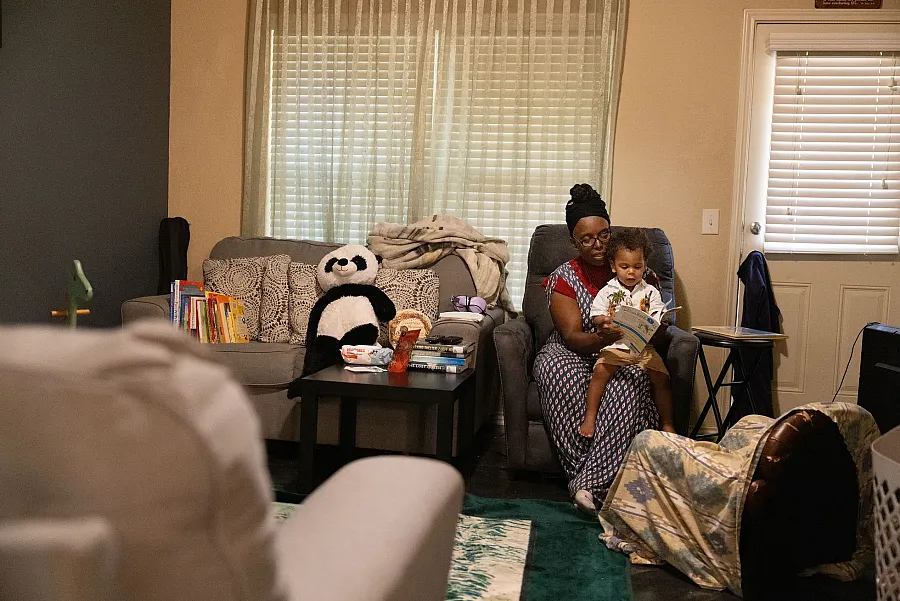 A person reading a book to a child