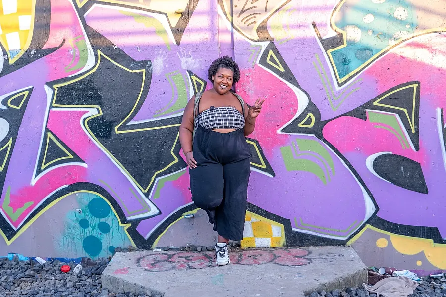 Person standing against a graffiti 