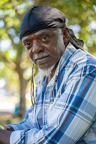 Person with blue shirt and black bandana