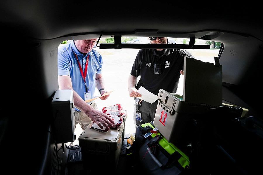 Image of two people doing paperwork on blood bags.