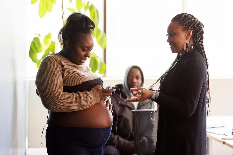 A lady with baby bump talking to a health care worker