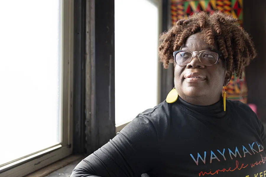 A person in black top and curly hair