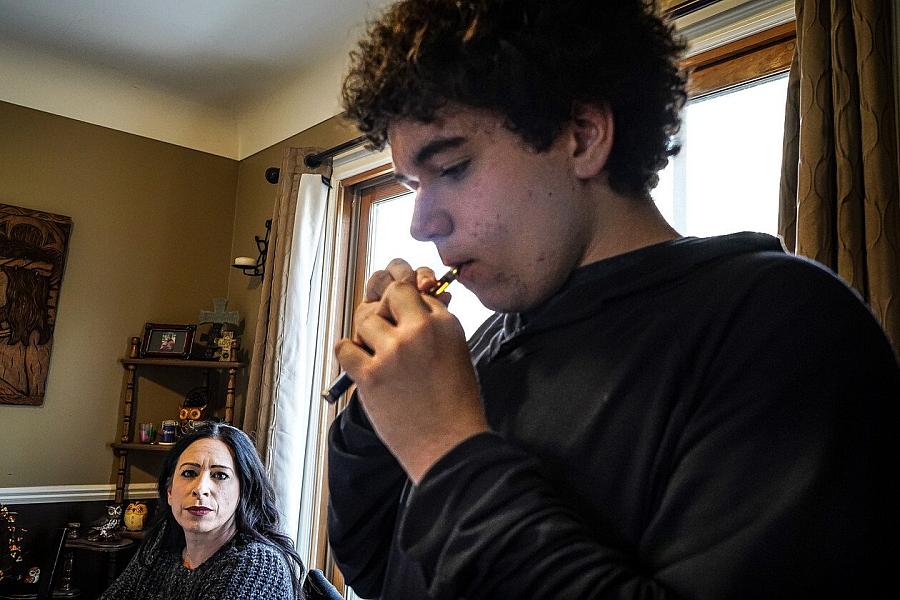 Amie Carter looks on while her son Jayden, 16, takes a hit from a vape pen filled with cannabis oil. | Natalie Fertig/POLITICO