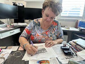 Image of a person working with lots of paper on desk