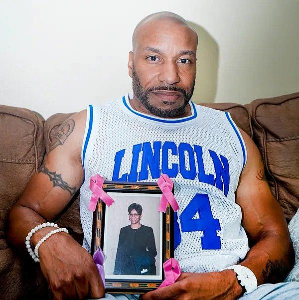An image of a person holding a photo frame of victim