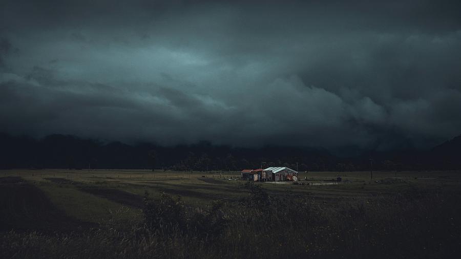 Scenic image of a home under cloudy dark sky