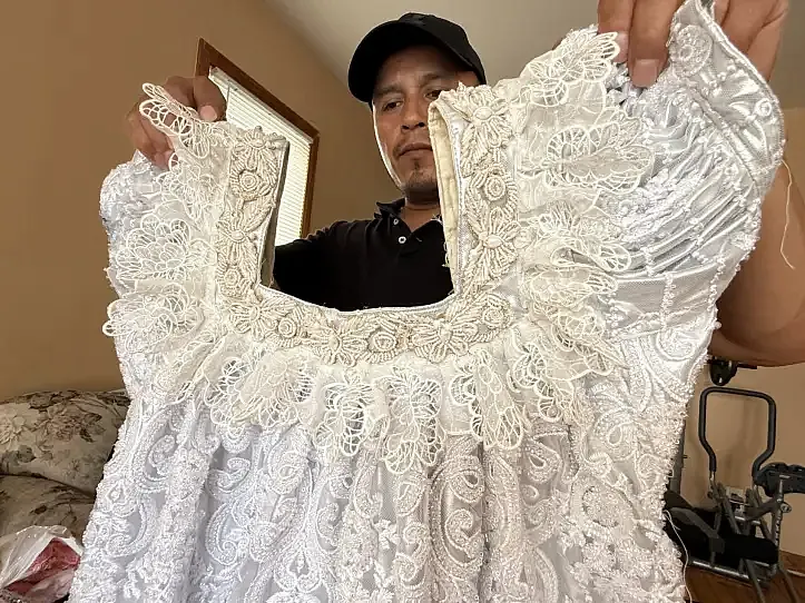 Catarino Castro holds up a huipil, a traditional garment worn by indigenous women in Guatemala