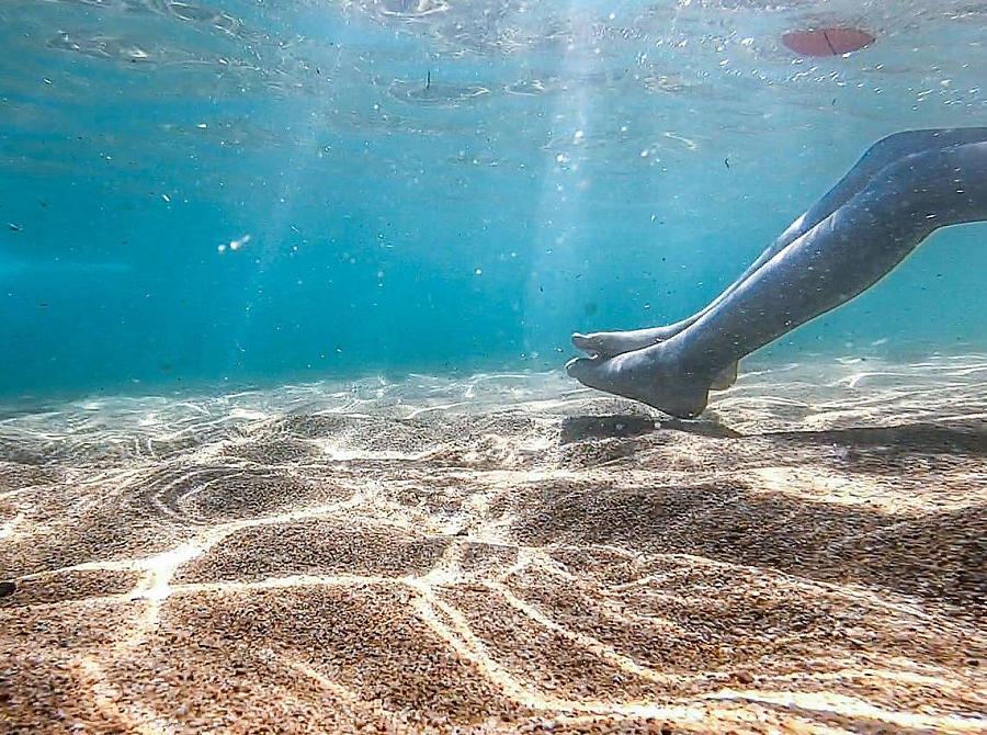 Image of lake bed with swimmer's legs