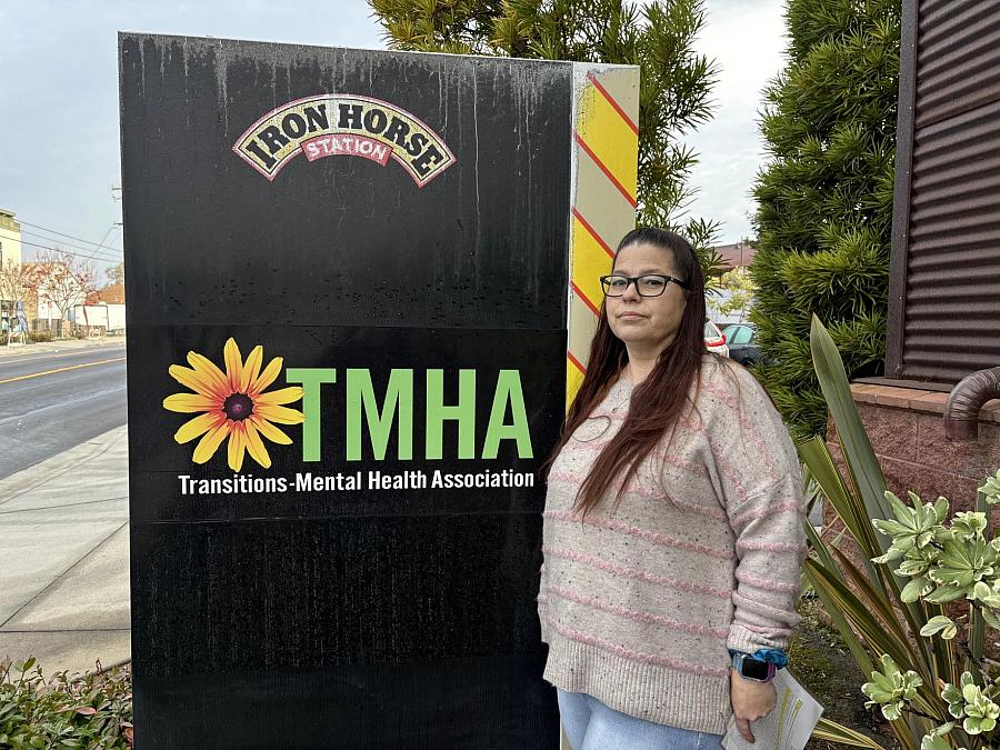 person standing by a TMHA sign