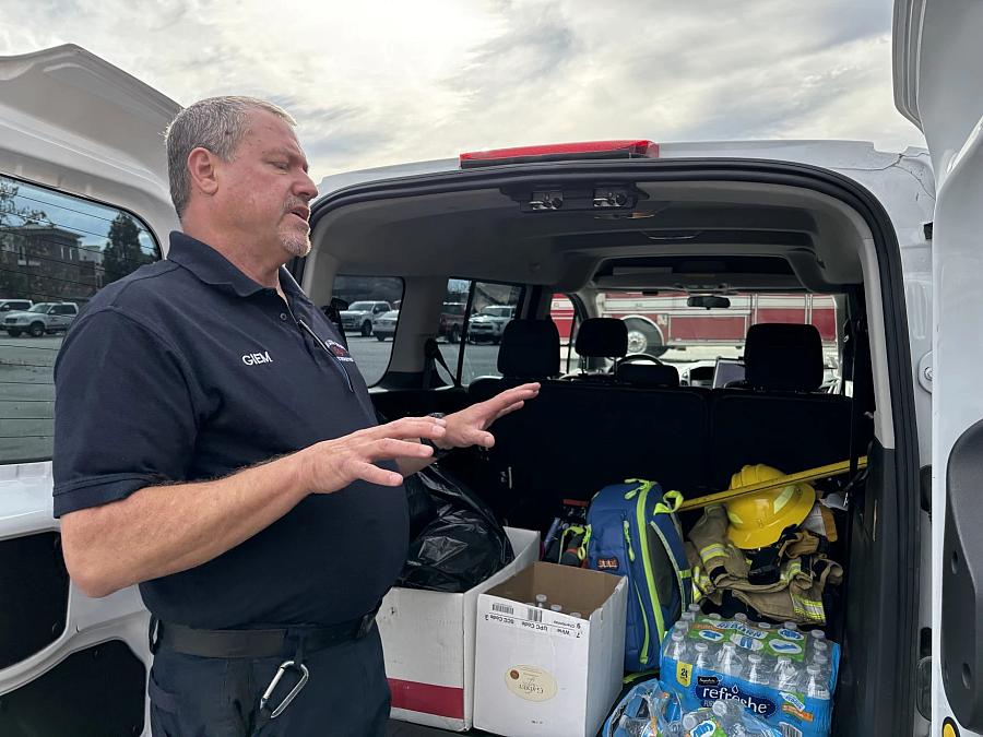 person standing by vehicle with supplies