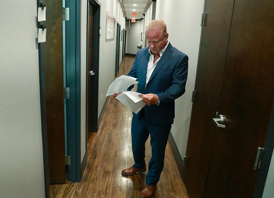 person standing in a corridor, reading