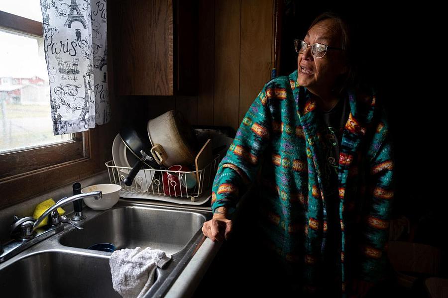 Person standing by sink, looking out a window