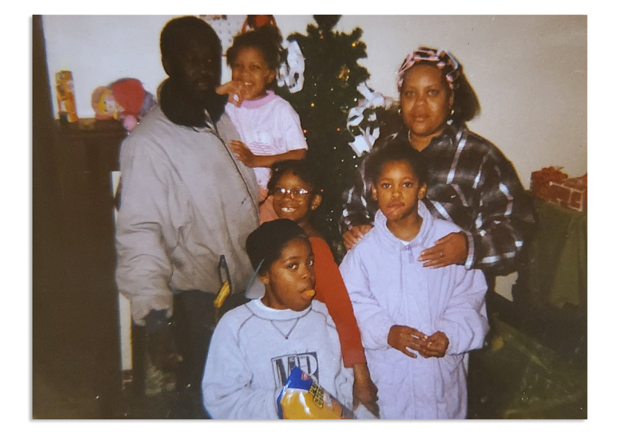 Family photo with two adults and four children in front of a Christmas tree.