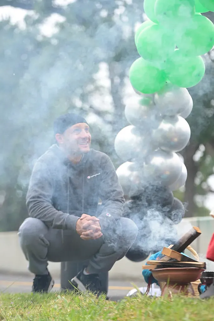 Person squatting besides burning sage