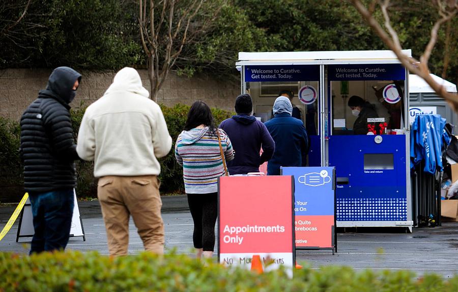 People standing in a queue of Covid 19 testing Kiosk