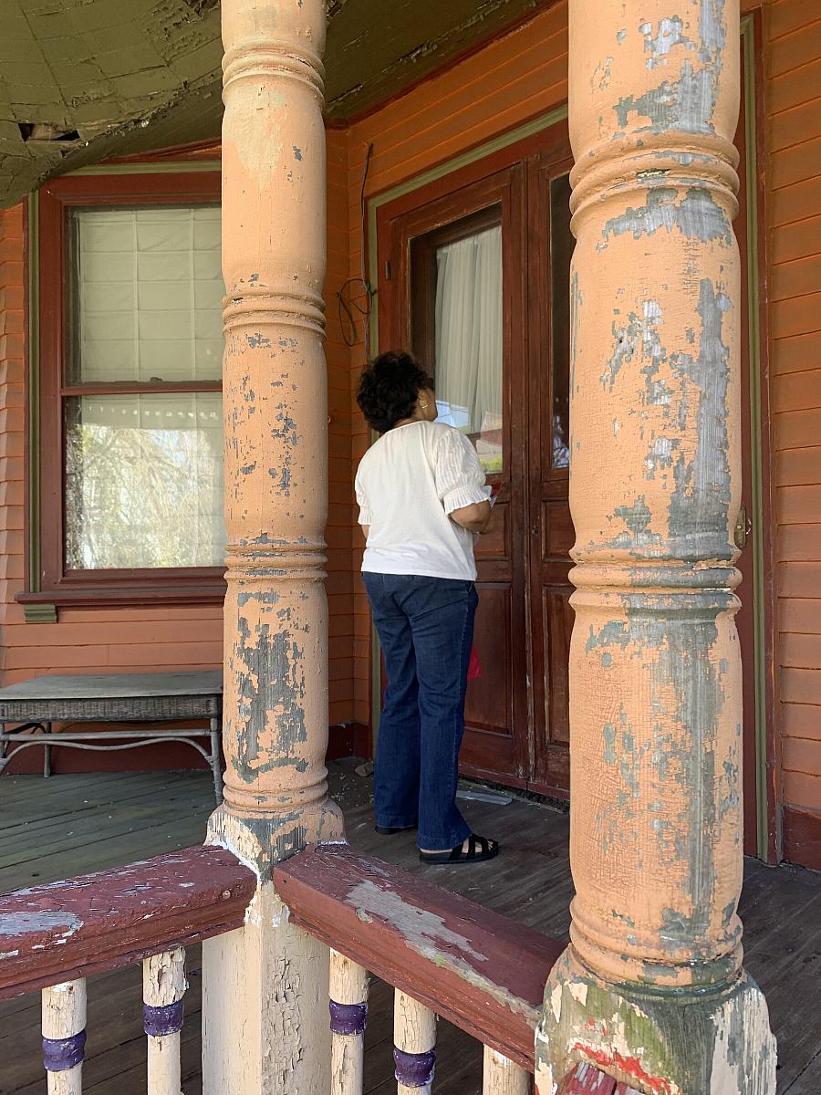 Person visiting house with peeling lead-based paint