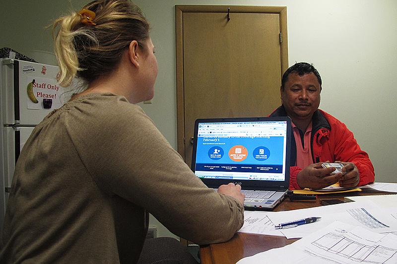 Birkha Tamang, a Bhutanese refugee, hopes to find an affordable health care plan. Assisting him is health navigator Leslie Bachurski of the Consumer Health Coalition. (Erika Beras/90.9 WESA) 