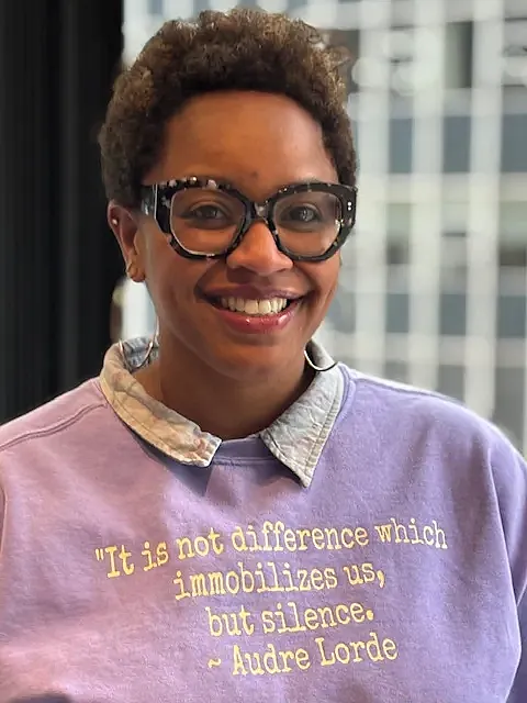 Person in violet top with spectacles