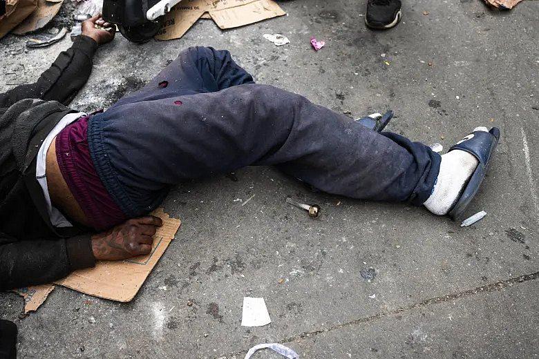 Homeless and addicted person passes out in an alley.