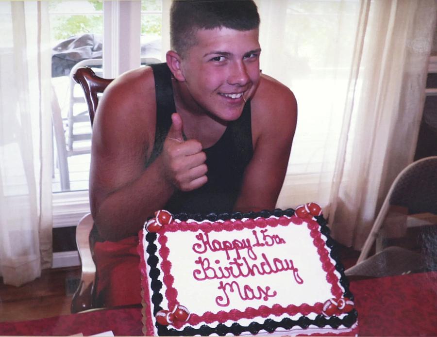 A boy doing thumbs on with his birthday cake